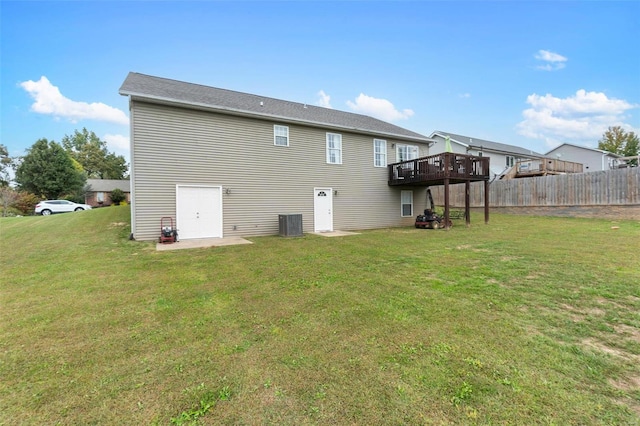 rear view of house featuring a wooden deck and a lawn