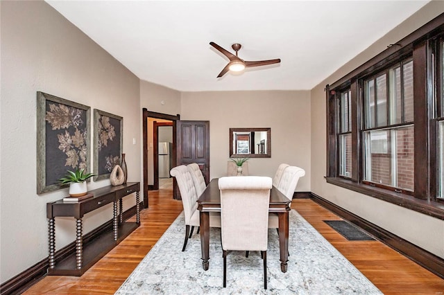 dining room with hardwood / wood-style flooring and ceiling fan