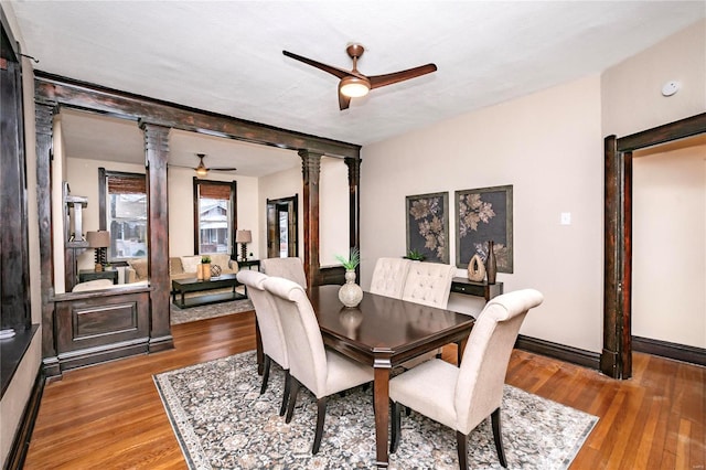 dining area with hardwood / wood-style floors, decorative columns, and ceiling fan