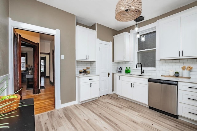 kitchen featuring pendant lighting, sink, stainless steel dishwasher, and white cabinets