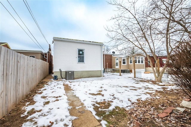 snow covered house with central AC