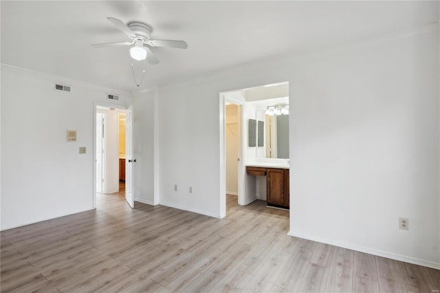 unfurnished bedroom featuring ensuite bathroom, ceiling fan, ornamental molding, and light hardwood / wood-style flooring