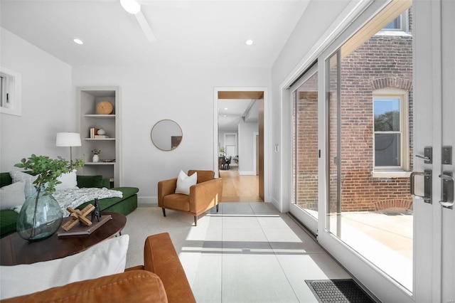 living room featuring built in features and light hardwood / wood-style floors