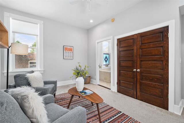 carpeted living room with ceiling fan and a healthy amount of sunlight