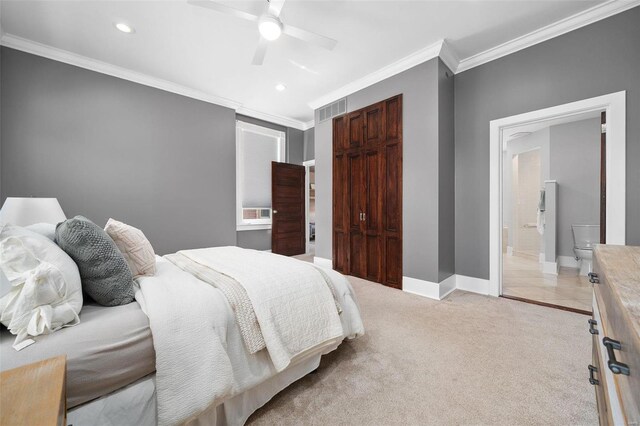 carpeted bedroom featuring ceiling fan, a closet, ensuite bath, and ornamental molding