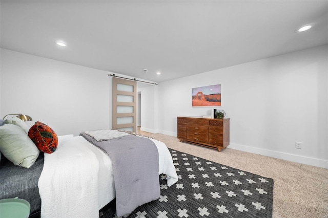 carpeted bedroom featuring a barn door