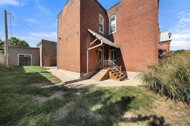 rear view of house featuring a yard and a shed