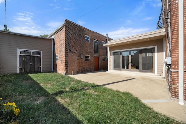 rear view of property featuring a patio and a yard