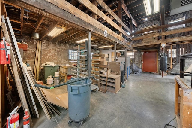 basement featuring brick wall and a wealth of natural light