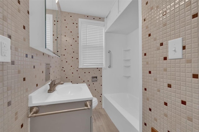 bathroom featuring hardwood / wood-style floors, vanity, toilet, and tile walls