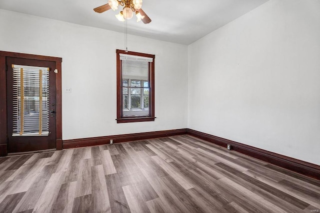 empty room with ceiling fan, hardwood / wood-style flooring, and a healthy amount of sunlight