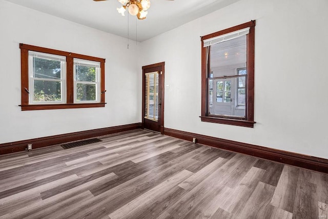 empty room with ceiling fan and hardwood / wood-style flooring