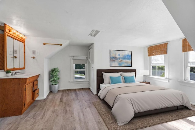 bedroom with light hardwood / wood-style floors and sink