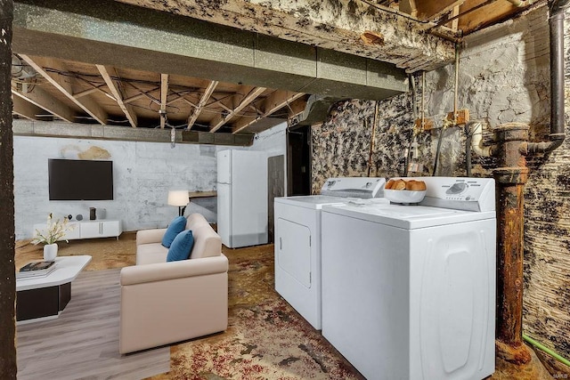 clothes washing area with separate washer and dryer and hardwood / wood-style floors