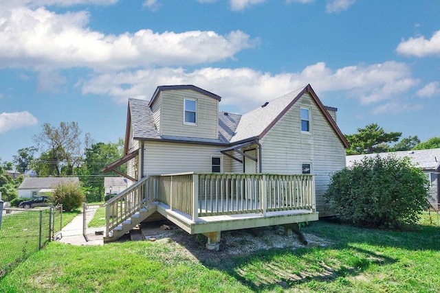 back of property featuring a lawn and a deck