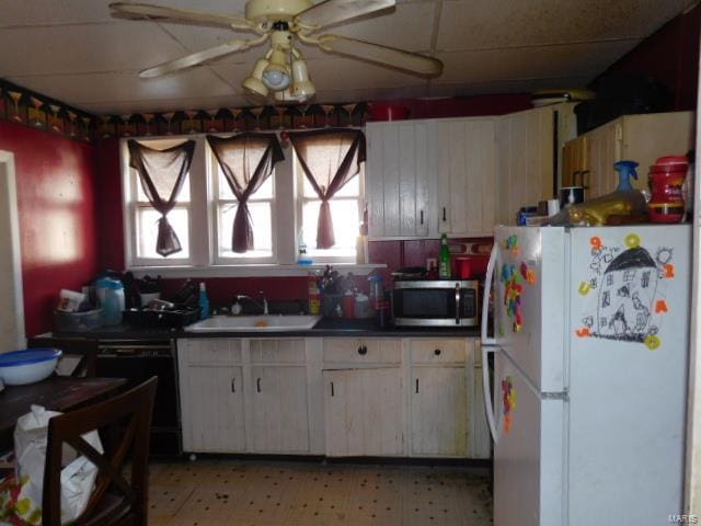 kitchen featuring dishwasher, white refrigerator, sink, white cabinets, and ceiling fan