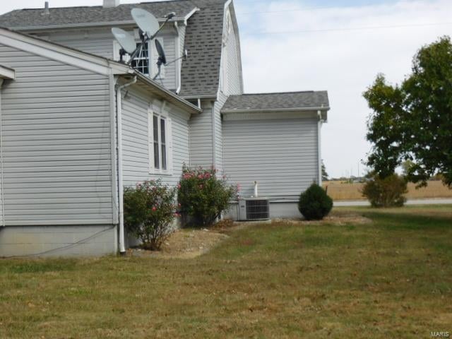 view of property exterior with a lawn and cooling unit