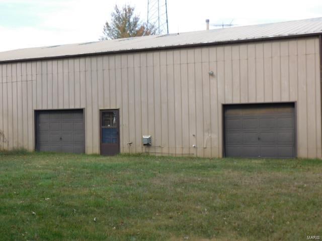 garage featuring wood walls and a lawn