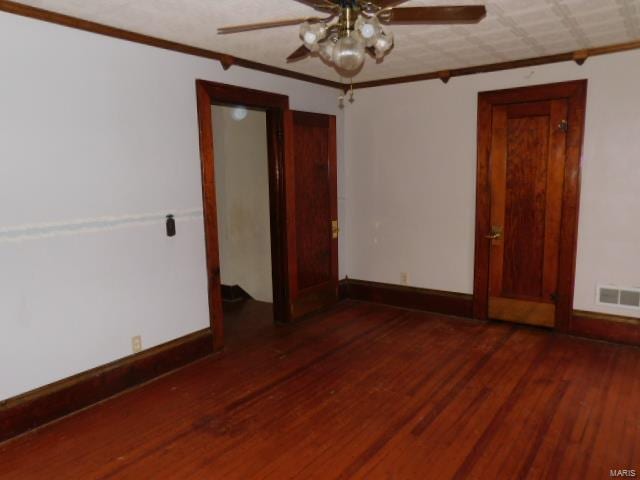 spare room with crown molding, dark wood-type flooring, and ceiling fan