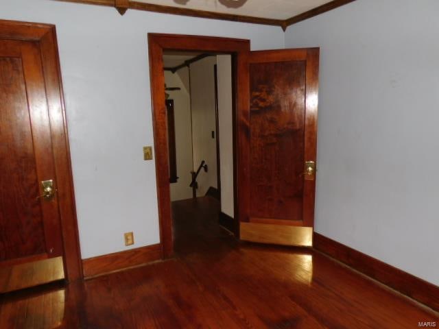 empty room with crown molding and dark hardwood / wood-style flooring