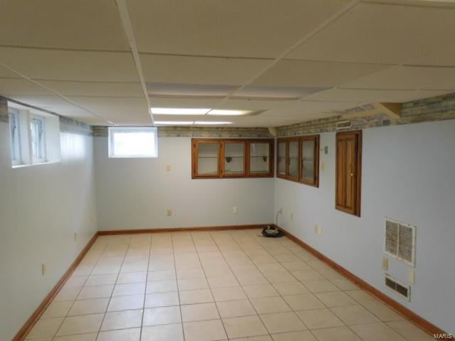 basement featuring heating unit and a drop ceiling