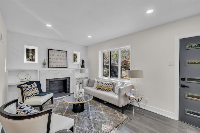 living room with a high end fireplace and wood-type flooring