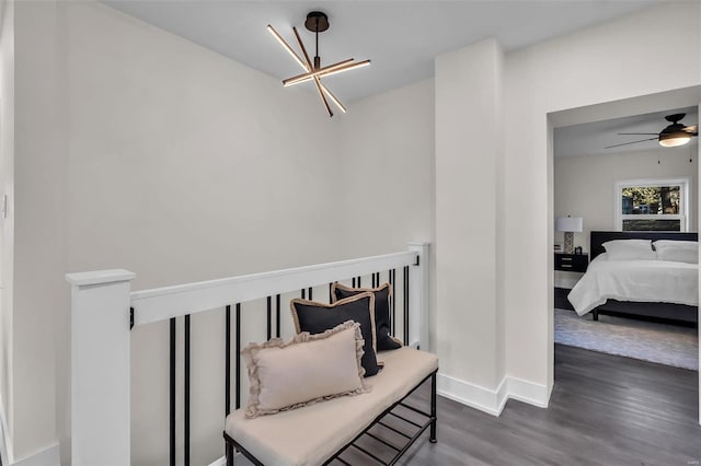 interior space featuring ceiling fan with notable chandelier and dark hardwood / wood-style floors