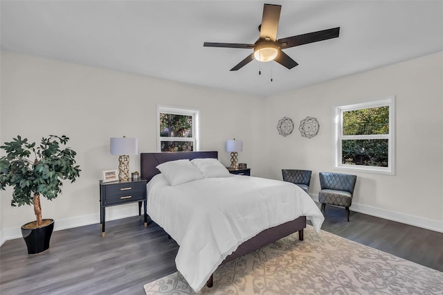 bedroom with multiple windows, dark wood-type flooring, and ceiling fan