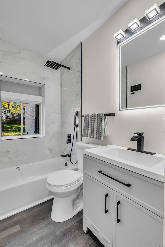 full bathroom with tiled shower / bath, toilet, vanity, and hardwood / wood-style flooring