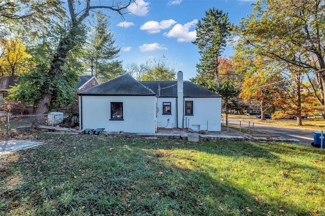 rear view of property featuring a lawn