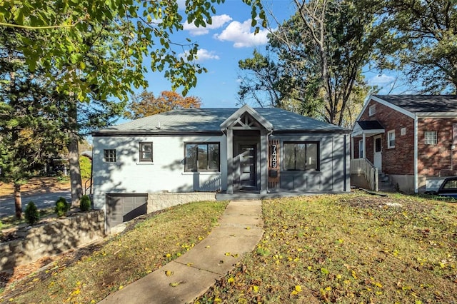 view of front of property featuring a garage and a front lawn