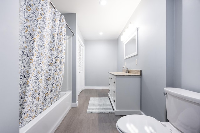 full bathroom featuring hardwood / wood-style floors, vanity, shower / tub combo with curtain, and toilet