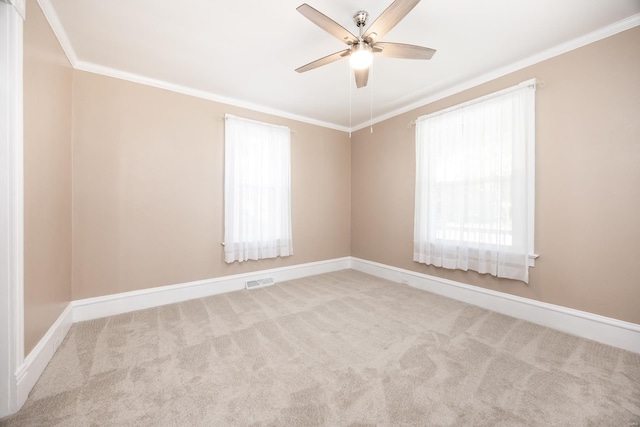 unfurnished room with crown molding, light colored carpet, and ceiling fan