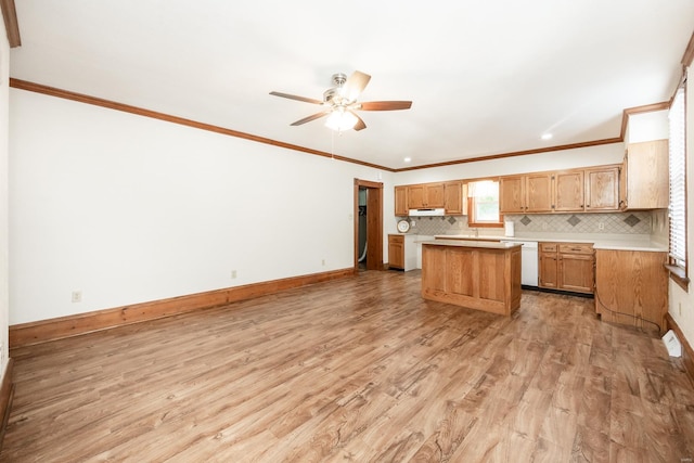 kitchen with ceiling fan, light wood-type flooring, ornamental molding, and a center island