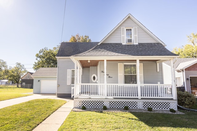 bungalow featuring a porch, a front yard, and a garage