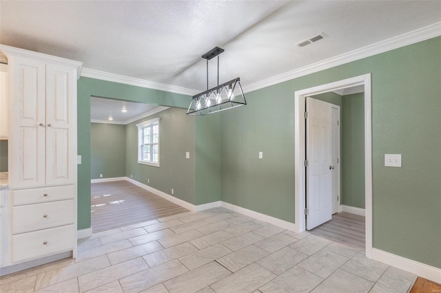 unfurnished dining area featuring ornamental molding, light wood-type flooring, and a textured ceiling