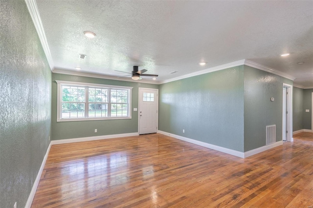 interior space with ceiling fan, ornamental molding, hardwood / wood-style flooring, and a textured ceiling