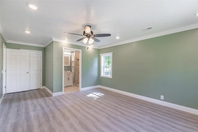 unfurnished bedroom featuring ceiling fan, a closet, light hardwood / wood-style floors, ensuite bath, and ornamental molding