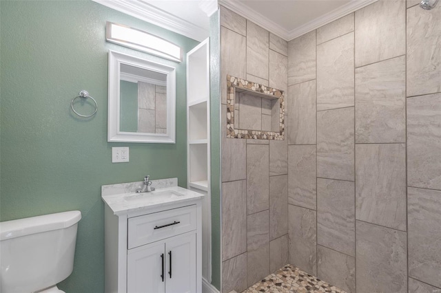 bathroom featuring crown molding, vanity, tiled shower, and toilet