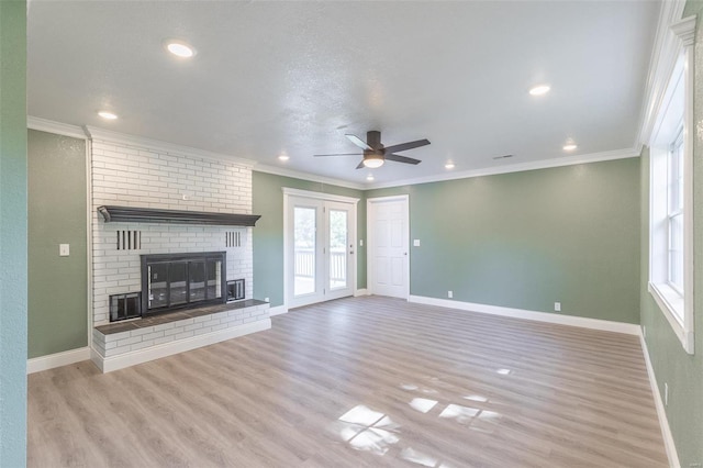 unfurnished living room with a fireplace, ornamental molding, light wood-type flooring, and ceiling fan