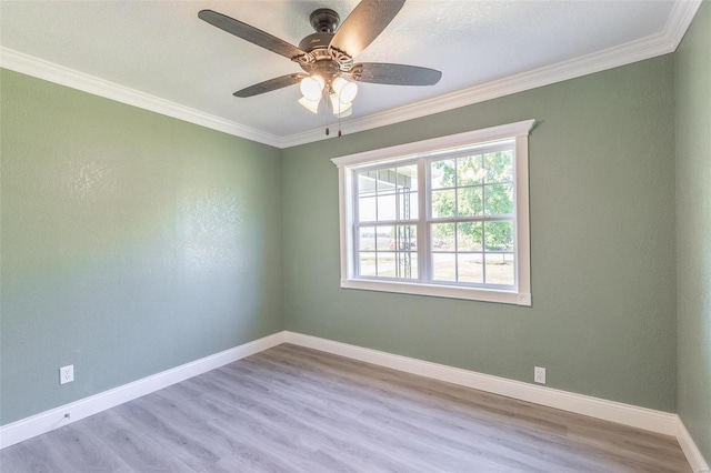 spare room featuring ceiling fan, light wood-type flooring, and crown molding