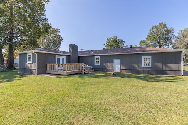 rear view of property featuring a wooden deck and a yard