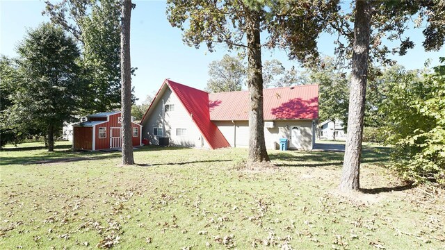 rear view of house with a yard and an outdoor structure