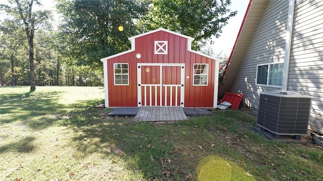 view of outbuilding featuring cooling unit and a lawn