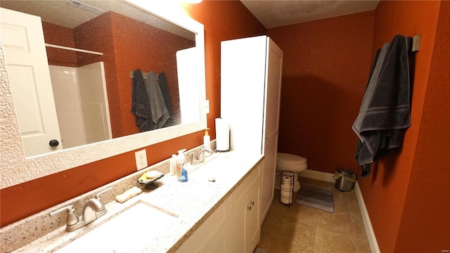 bathroom with tile patterned floors, vanity, toilet, and a shower