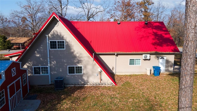 back of house featuring central air condition unit, a yard, and a wall mounted AC