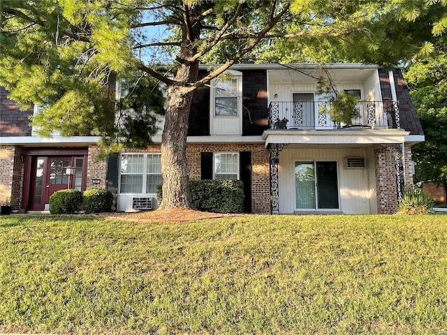 rear view of house with a balcony and a lawn