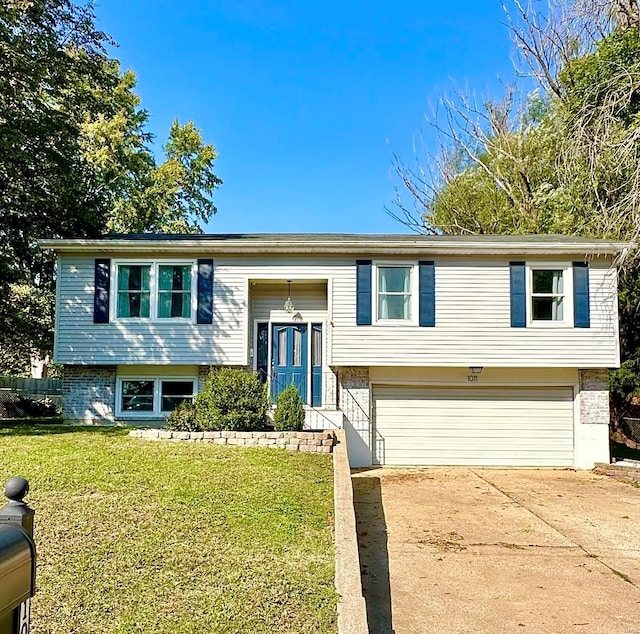 bi-level home featuring a garage and a front lawn