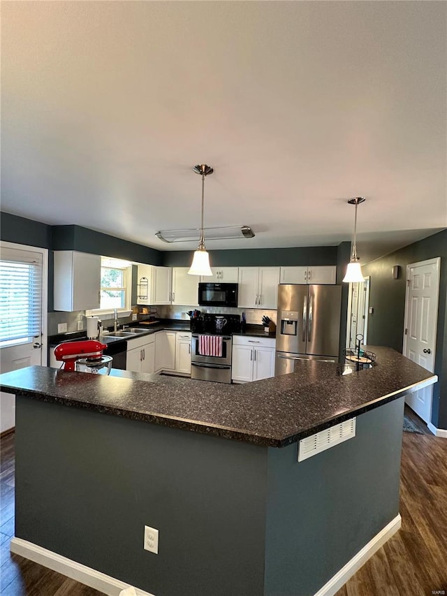 kitchen featuring pendant lighting, stainless steel appliances, and a wealth of natural light