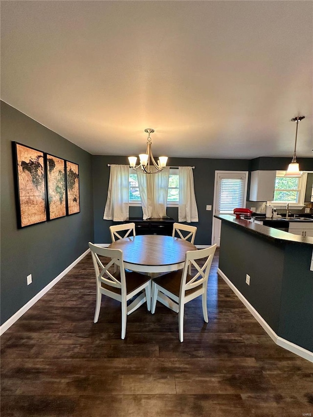 dining room with dark hardwood / wood-style floors, sink, and a notable chandelier